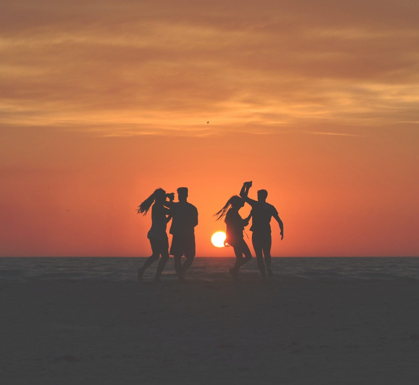 A group of people standing on top of a beach.