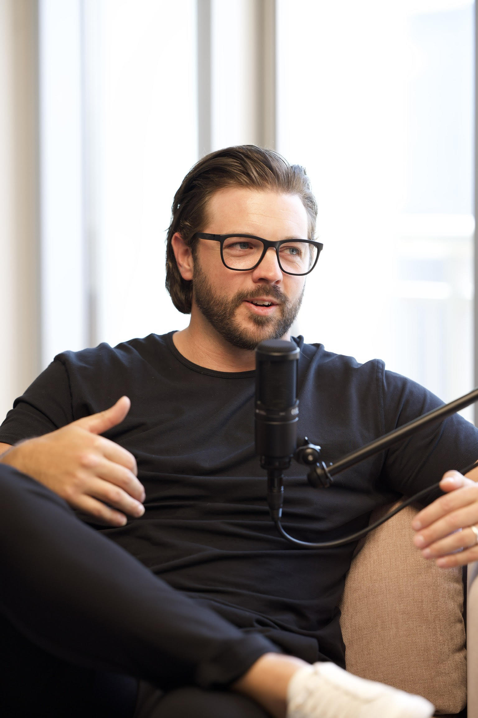 A man with glasses is sitting down